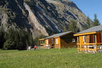 Camping Des Glaciers -  Chalet mit Veranda im Grünen auf dem Campingplatz