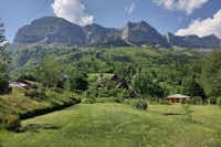 Camping des Petites Roches - Wiese mit Stanplätzen des Campingplatzes und Ausblick auf die französischen Alpen