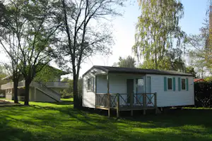 Camping des Varennes - Mobilheim vom Campingplatz mit Veranda zwischen Bäumen