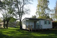 Camping des Varennes  -  Mobilheim vom Campingplatz mit Veranda zwischen Bäumen
