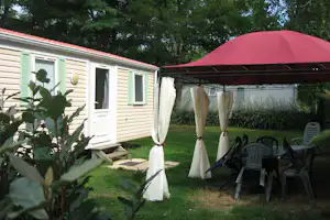 Camping des Varennes - Außenansicht Mobilheim und Esstisch unter einem Pavillon