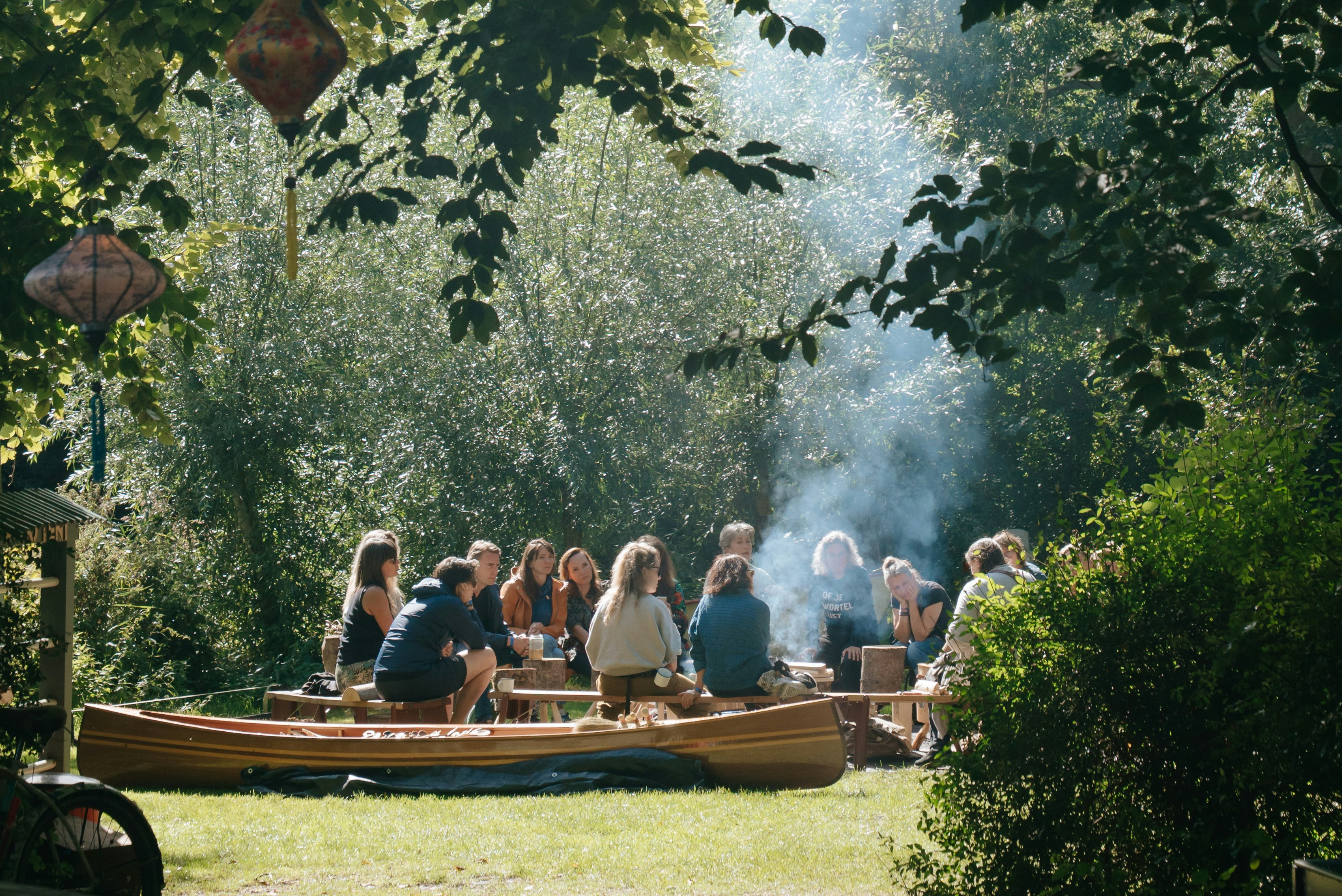 Camping Dijk & Meer - Camper sitzen gemeinsam am Lagerfeuer