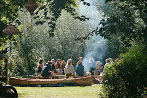 Camping Dijk & Meer - Camper sitzen gemeinsam am Lagerfeuer