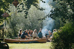 Camping Dijk & Meer - Camper sitzen gemeinsam am Lagerfeuer
