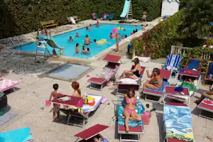 Camping Dolce Vita - Camper auf Liegestühlen am Pool vom Campingplatz