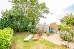 Camping Domaine de Bel Air - Glampingzelt mit Beet davor und Sonnenliegen daneben