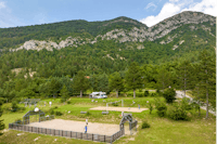Camping Domaine des 2 Soleils - Blick auf den Campingplatz mit Sportplätzen und Bergen im Hintergrund