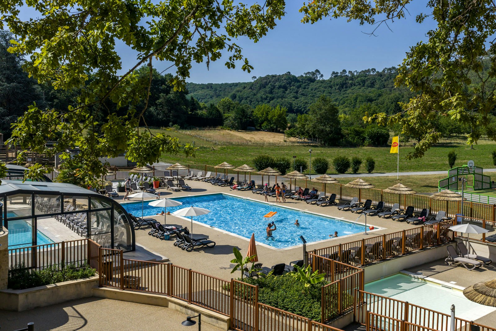 Camping Domaine des Chênes Verts  - Pool im Freien mit Liegestühlen und Sonnenschirmen