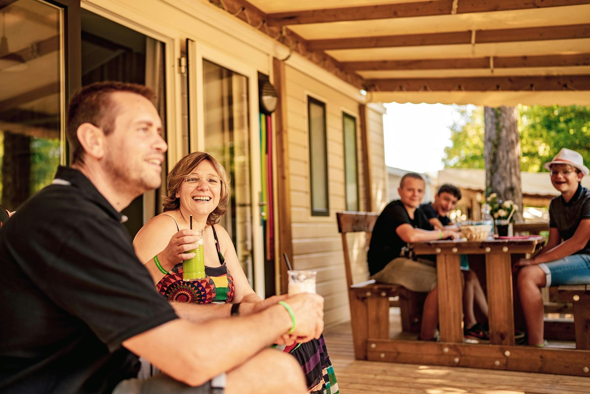 Camping Domaine des Chênes Verts - Camper genießen Getränke auf der Terrasse ihrer Mietunterkunft