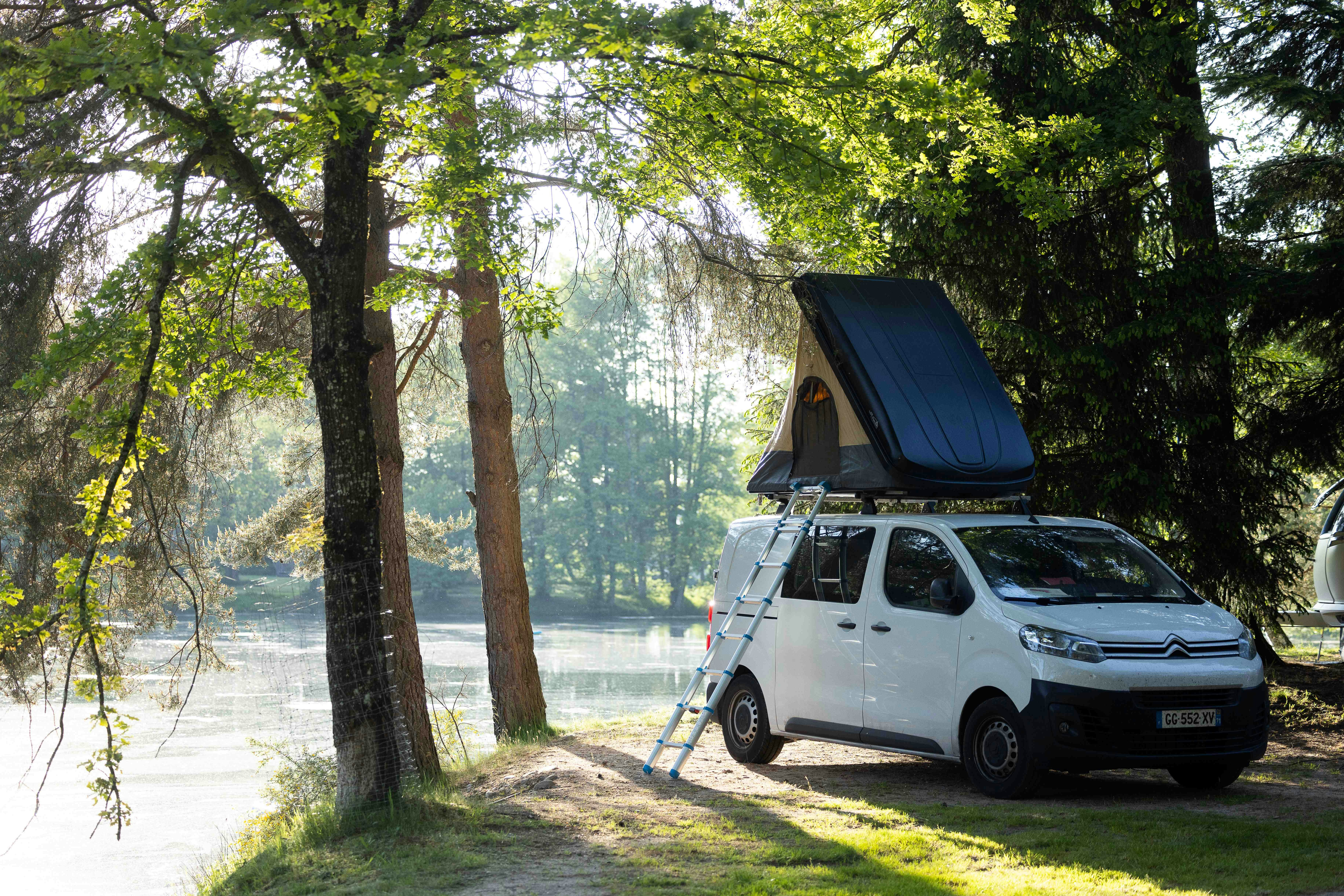 Camping Domaine des Messires - Blick auf einen Standplatz zwischen Bäumen direkt am See