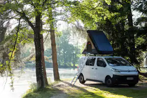 Camping Domaine des Messires - Blick auf einen Standplatz zwischen Bäumen direkt am See