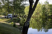 Camping Domaine des Messires - Standplätze am Ufer des Sees umgeben von Bäumen