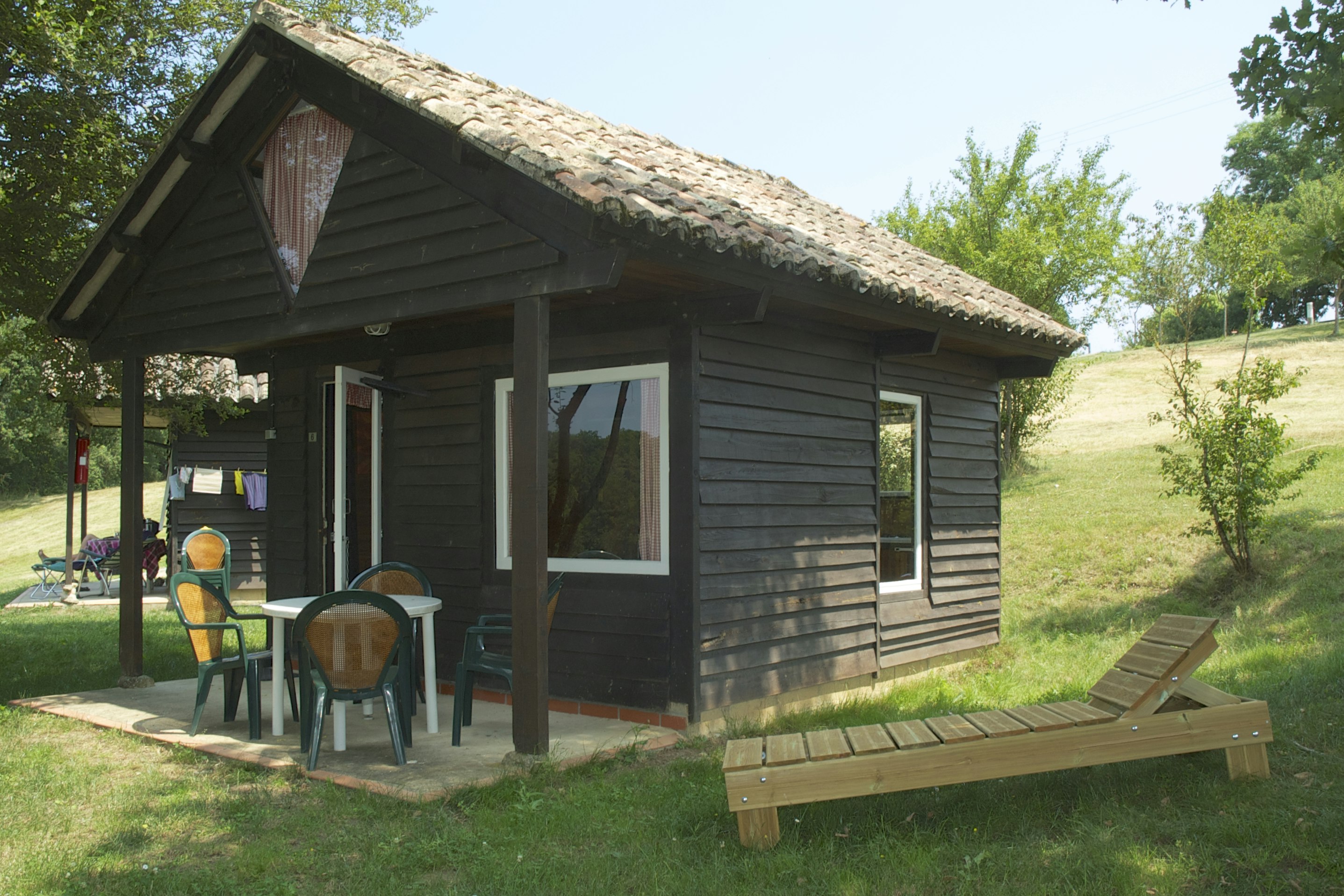 Camping Domaine Laborde  -  Mobilheim vom Campingplatz mit Esstisch und Liegestuhl außen