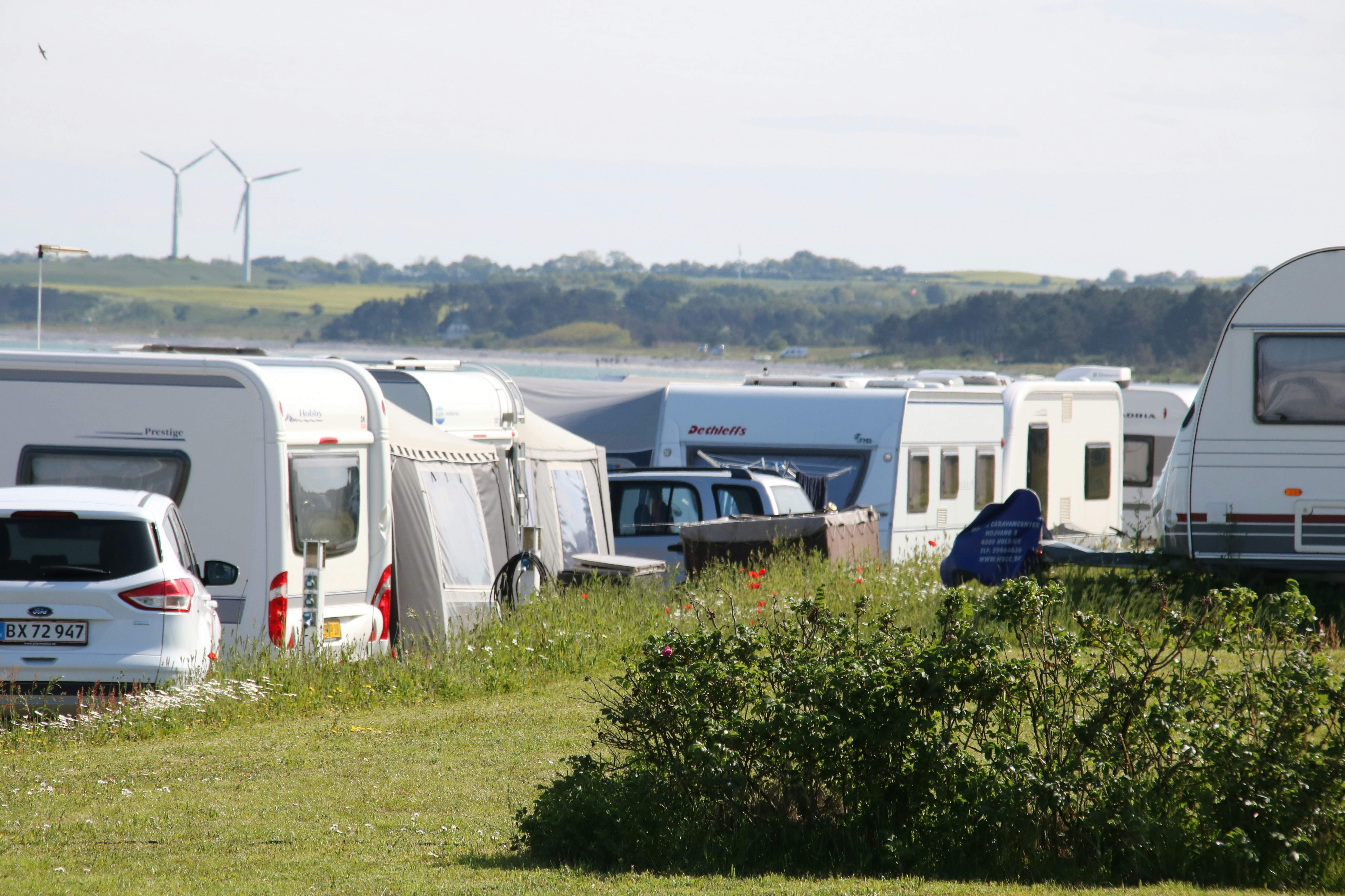 Camping Dråby Strand  -  Wohnwagen und Wohnmobile auf dem Stellplatz vom Campingplatz im Grünen