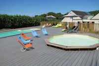 Der Pool des Camping Du Bas de la Landes in Morbihan mit Liegestühlen, Sonnenschirmen und Kinderbecken