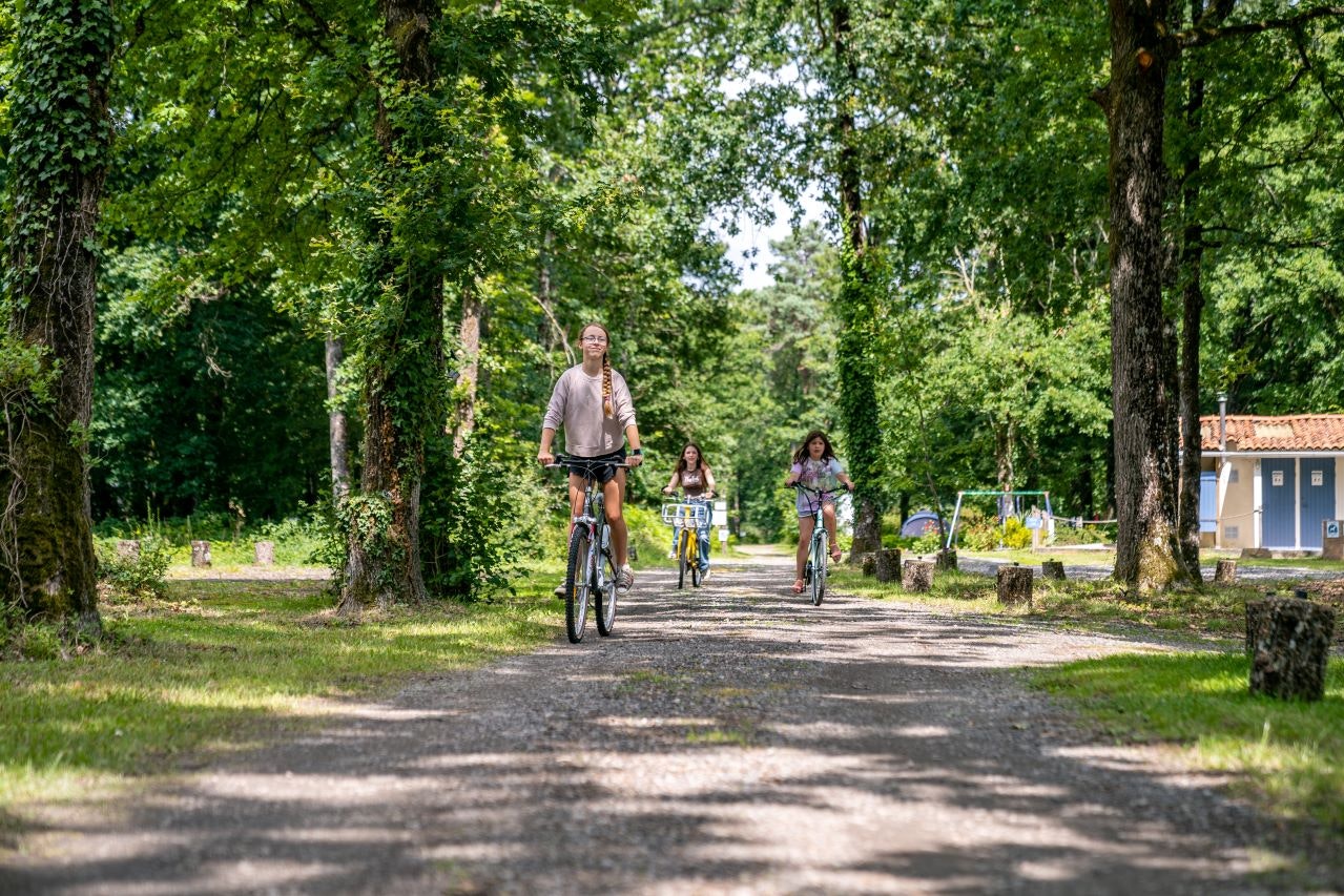 Camping Du Bois de St. Hilaire - Kinder mit Fahrrädern auf dem Campingplatz