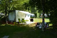 Camping du Gît - Wohnmobil mit Campingstühlen davor im Grünen