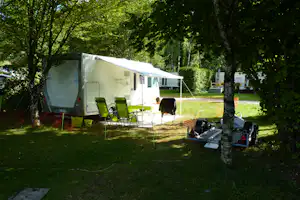 Camping du Gît - Wohnmobil mit Campingstühlen davor im Grünen