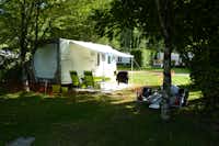 Camping du Gît - Wohnmobil mit Campingstühlen davor im Grünen