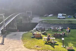 Camping du Moulin - Sitzgelegenheiten auf der Wiese am Ufer des Flusses