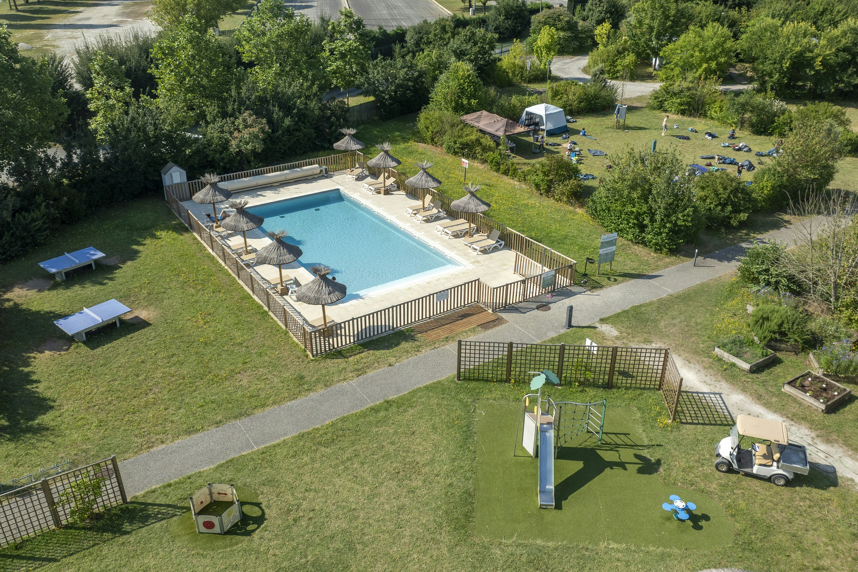 Camping du Plan d'Eau - Blick auf den Pool und den Kinderspielplatz