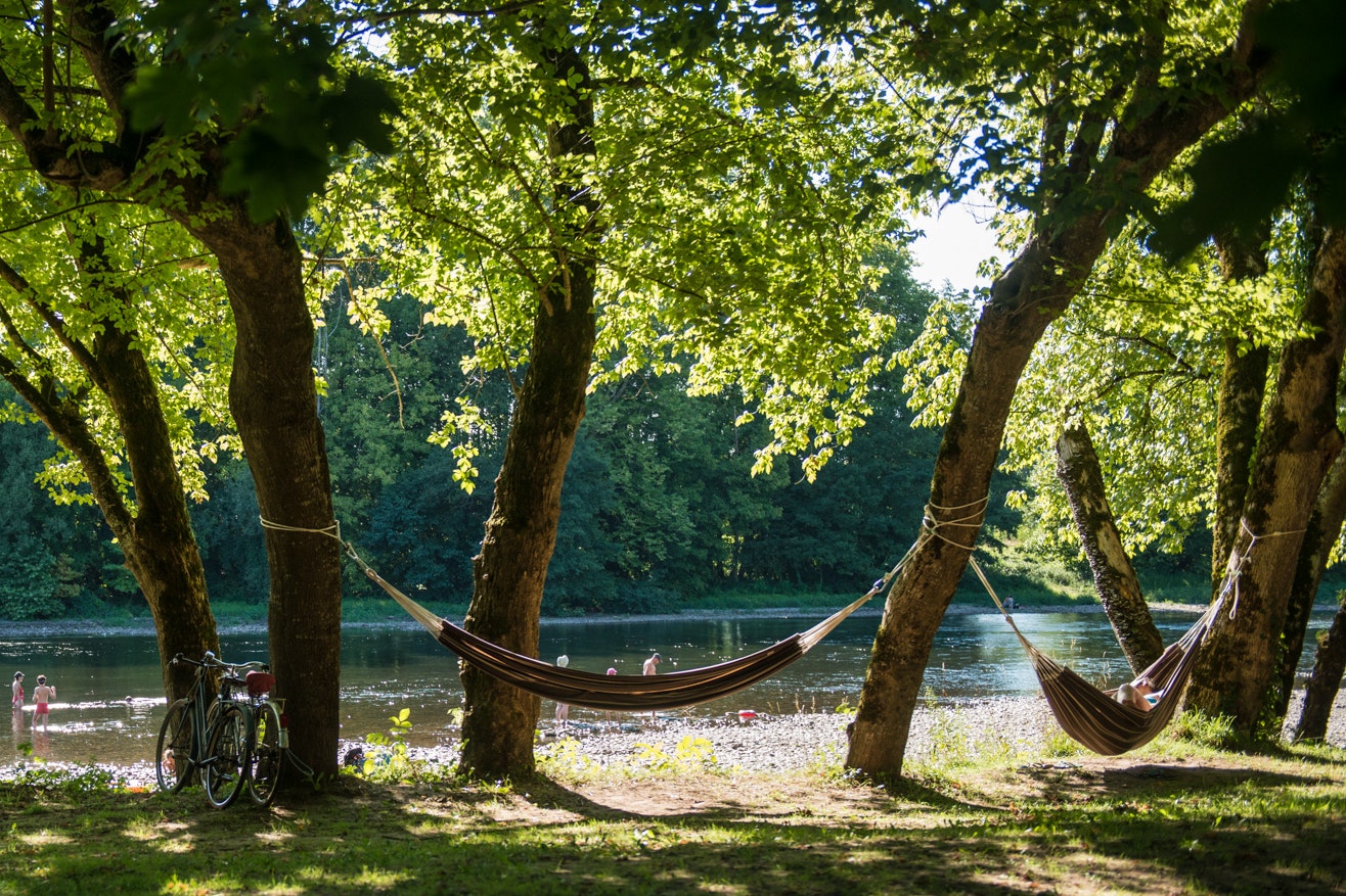 Camping Du Port - Hängematten zwischen Bäumen am Wasser
