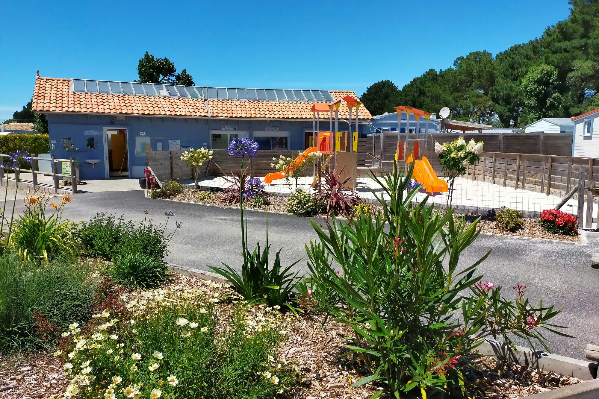 Camping du Vieux Château - Außenansicht Sanitärgebäude und Spielplatz
