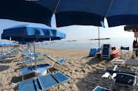 Camping Duca Amedeo -  - Strand mit Liegestühlen und Sonnenschirmen auf dem Campingplatz