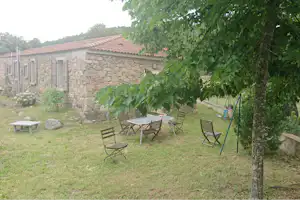 Camping e Canicce -Tisch und Stühle auf dem Rasen im Grünen auf dem Campingplatz