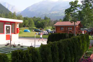 Camping Eggishorn-Z'moosji - Gebäude des Campingplatzes und Holzhütte vor einer Hecke