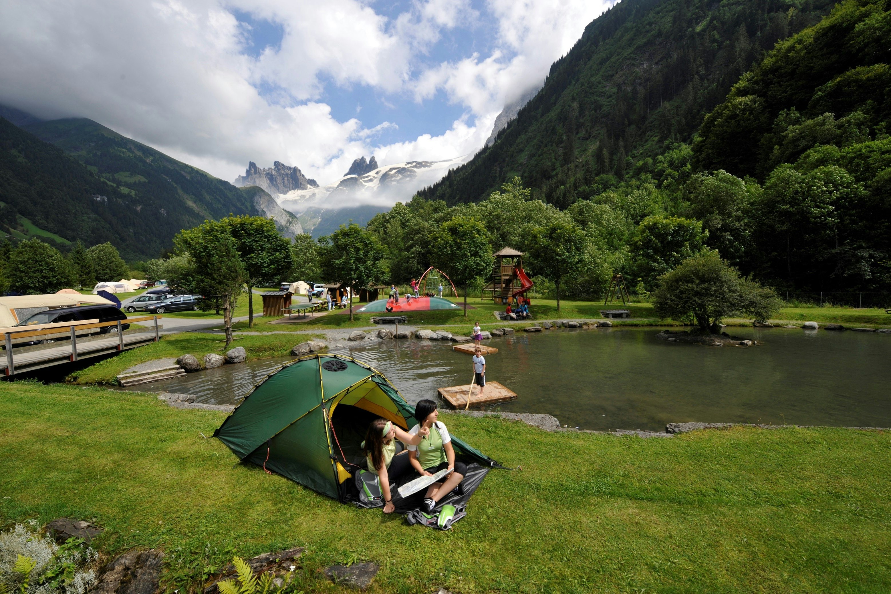 Camping Eienwäldli - Zeltplatz und spielende Kinder am Teich mit Blick auf die Berge