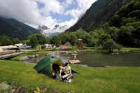 Camping Eienwäldli - Zeltplatz und spielende Kinder am Teich mit Blick auf die Berge