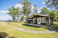 Nordic Camping Ekudden - Mobilheim neben Wohnwagenstellplätzen auf grüner Wiese auf dem Campingplatz