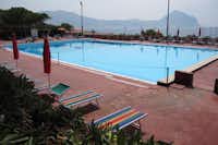 Camping El-Bahira - Der Swimmingpool auf dem Campingplatz mit Liegestühlen und Sonnenschirmen am Rand