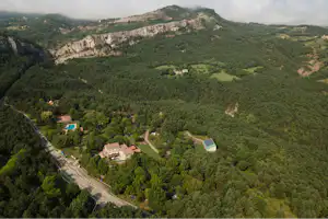 Huttopia Barcelona Pirineos - Campingplatz umgeben von Wald aus der Vogelperspektive