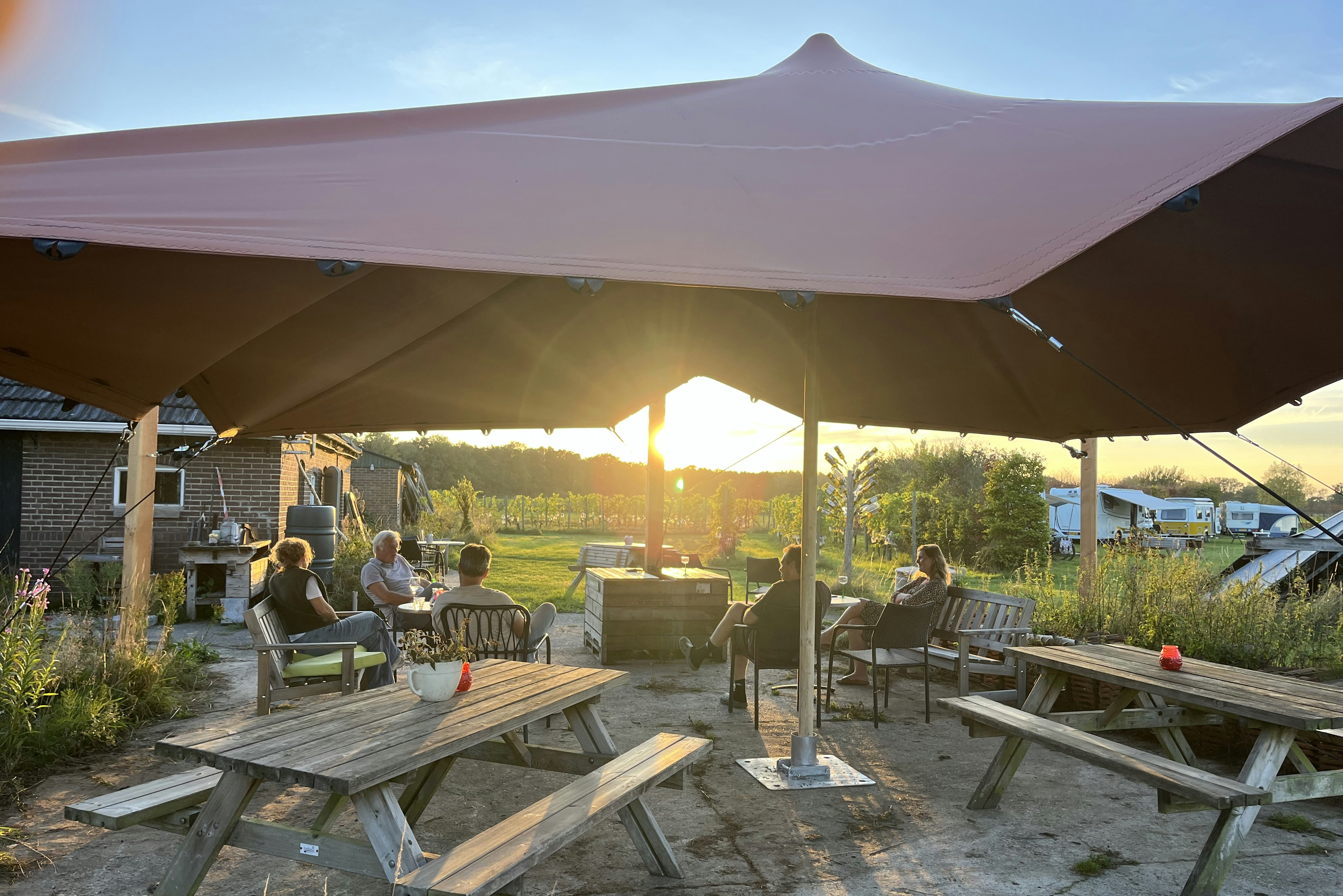 Erve Zonnehoeve - Terrasse mit Picknickbänken und Sonnensegel auf dem Campingplatz