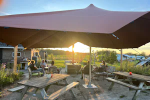Erve Zonnehoeve - Terrasse mit Picknickbänken und Sonnensegel auf dem Campingplatz