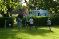 Camping et Gîtes Des Bains  - Kinder spielen Fußball auf dem Wohnwagen- und Zeltstellplatz vom Campingplatz im Grünen
