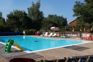 Camping Ferme de Prunay - Pool mit Liegestühlen und Sonnenschirmen auf dem Campingplatz