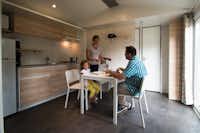 Team Camping Floreal Kempen - Innenraum der Küche mit Familie am Esstisch