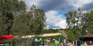 Camping Fontana - Poolbereich vom Campingplatz mit Wasserrutsche und mit Liegestühlen in der Sonne