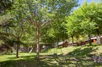 Camping Fontfreda -  Spielplatz  unter Bäumen auf dem Campingplatz