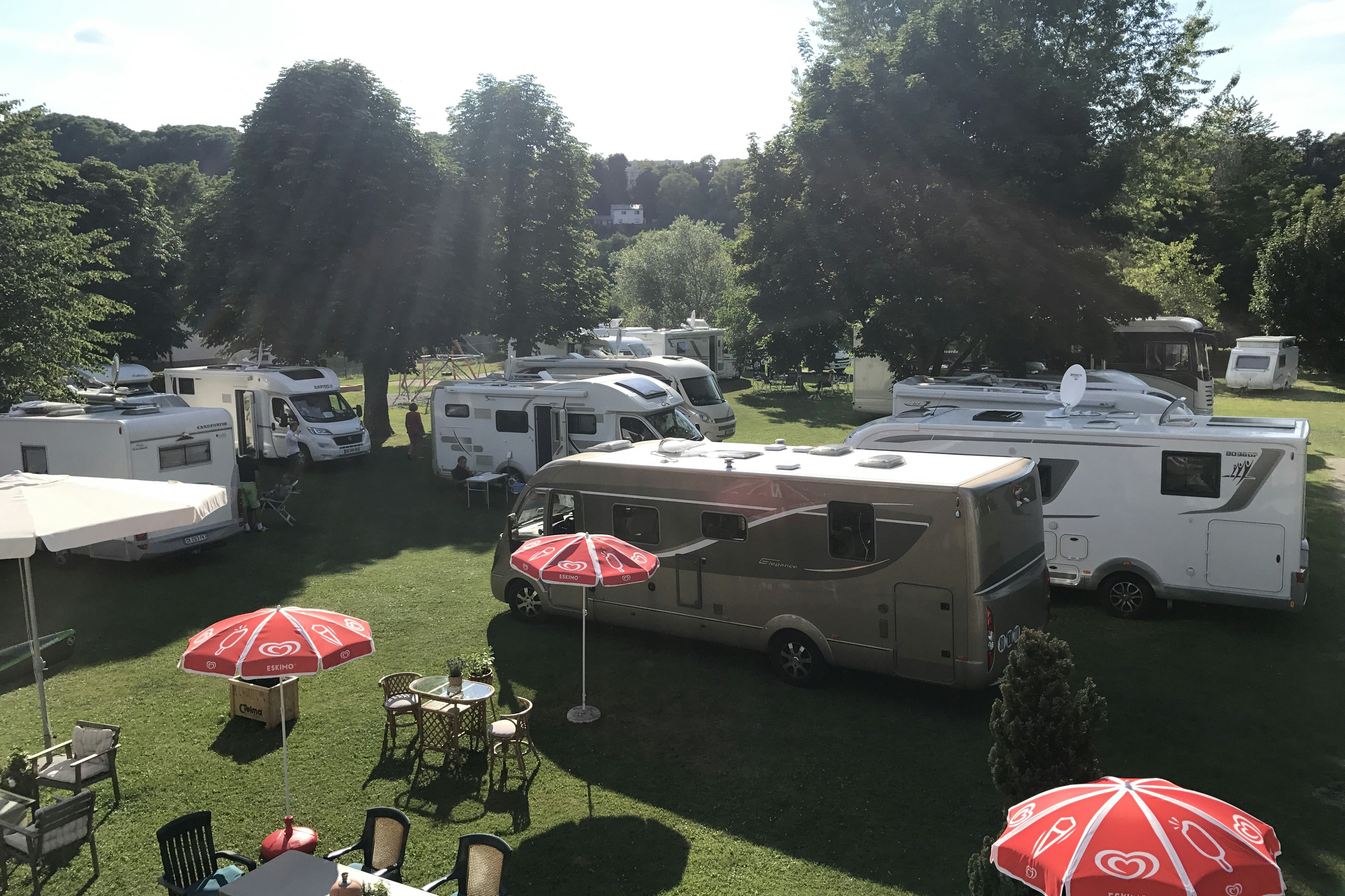 Camping am Fluss  -  Wohnmobilstellplätze auf Rasen zwischen Bäumen