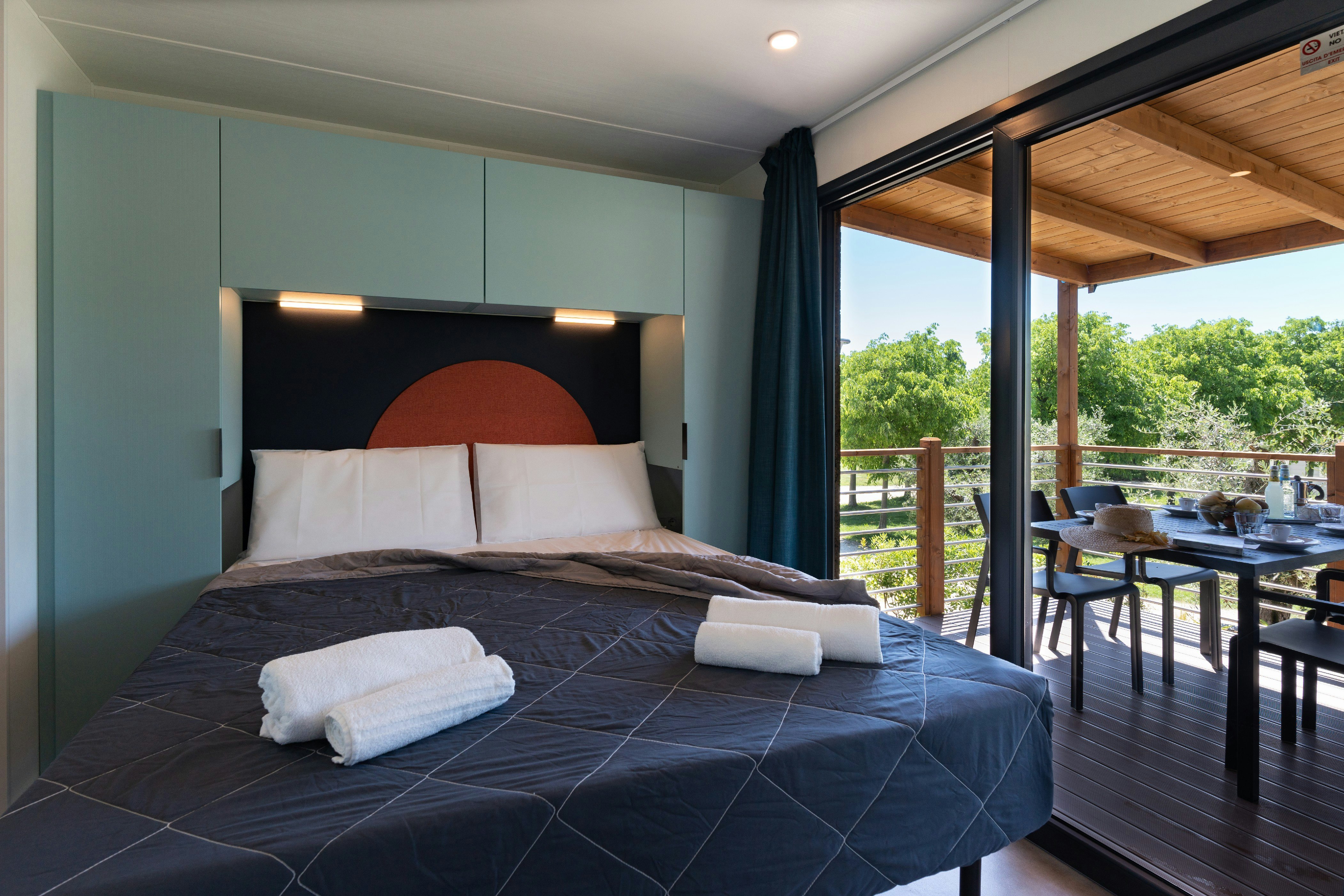 Fornella Camping & Wellness Family Resort  Camping Fornella - Doppelbett in einem Mobilheim auf dem Campingplatz