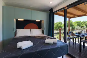 Fornella Camping & Wellness Family Resort Camping Fornella - Doppelbett in einem Mobilheim auf dem Campingplatz