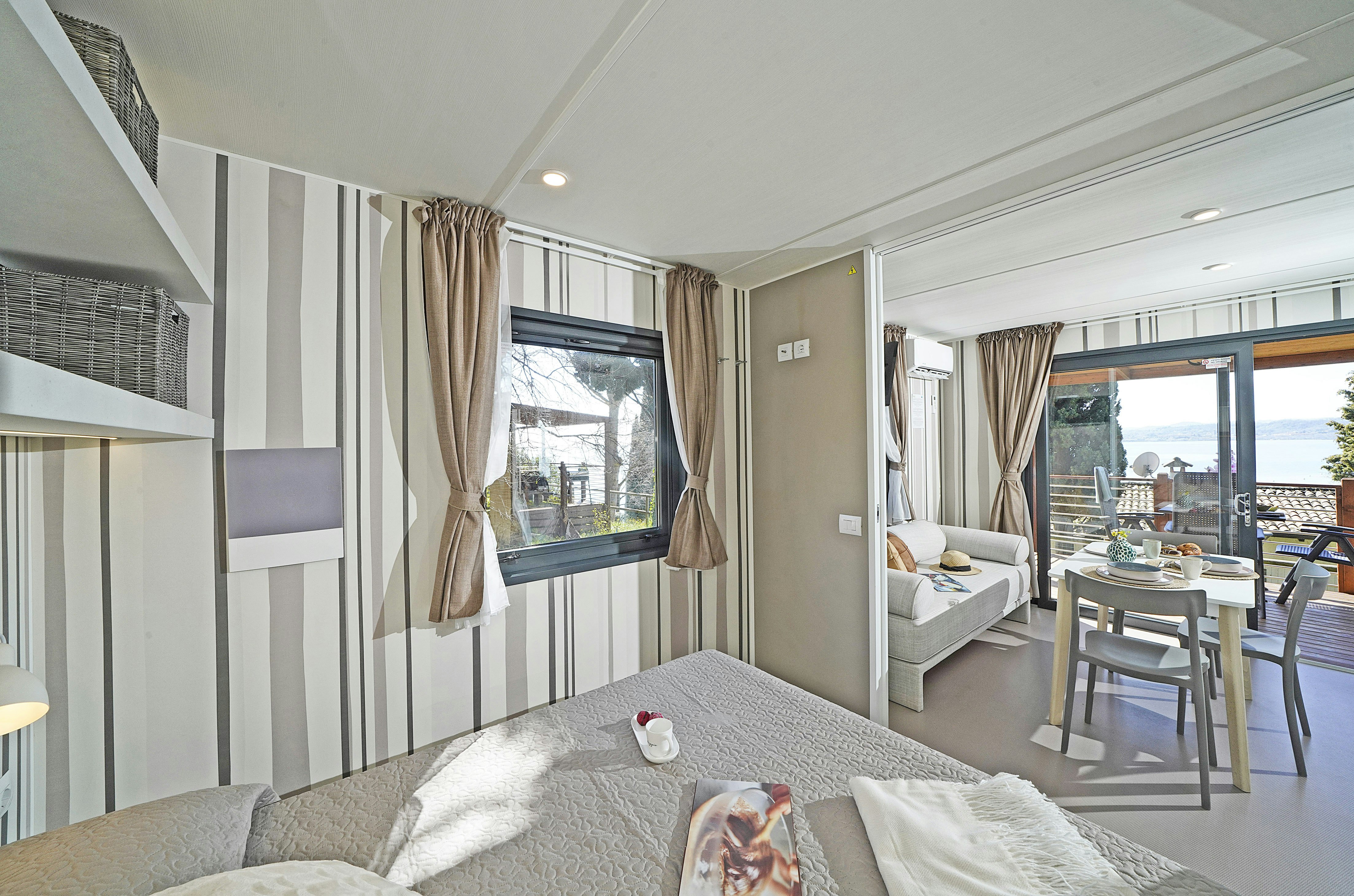 Fornella Camping & Wellness Resort  - Innenansicht eines Mobilheims mit Doppelbett und Terrasse