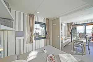 Fornella Camping & Wellness Resort - Innenansicht eines Mobilheims mit Doppelbett und Terrasse