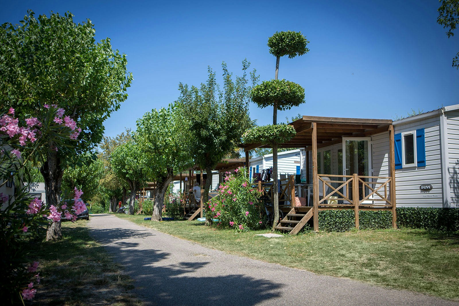 Camping Fossalta - Mobilheime mit Veranden an einer Strasse des Campingplatzes