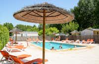 Camping Fouguières - Swimmingpool mit Liegestühlen und Sonnenschirmen auf dem Campingplatz