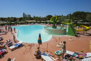 Großes Camping-Schwimmbecken mit Wasserrutsche, Whirlpool und vielen Sonnenliegen auf der Terrasse.